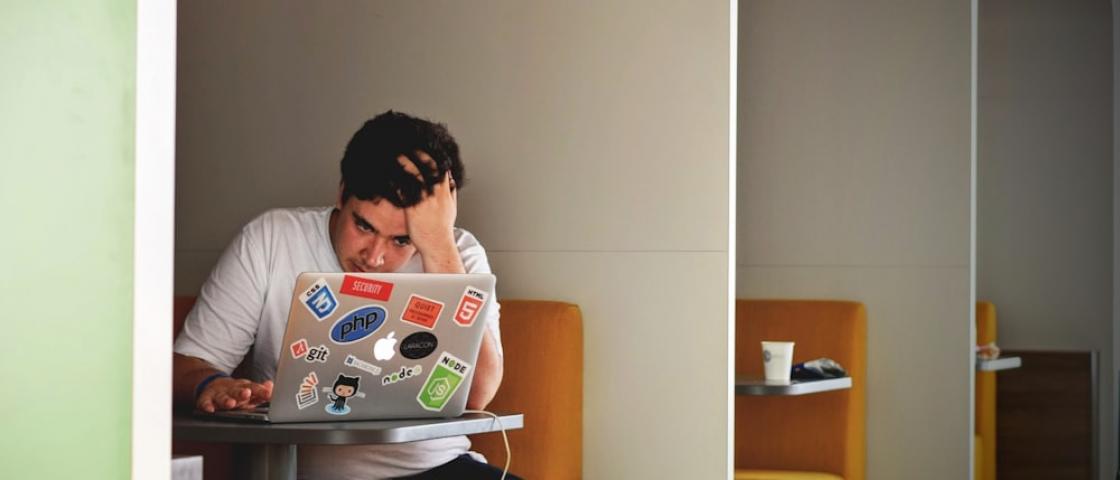 Laptop, książki i notatki na biurku — praca nad dyplomem